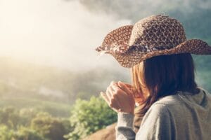 Woman holding a cup of coffee with beautiful landscape